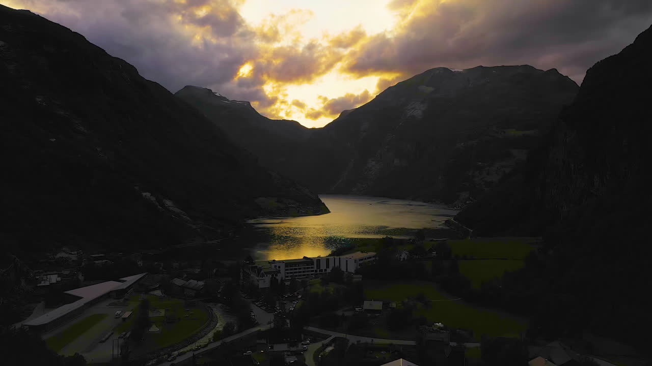 Aerial ascending shot of the Geirangerfjord, dramatic cloudy sunset in Norway