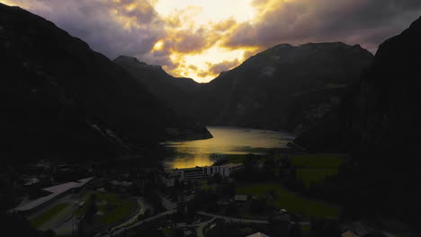 aerial ascending shot of the geirangerfjord, dramatic cloudy sunset in norway