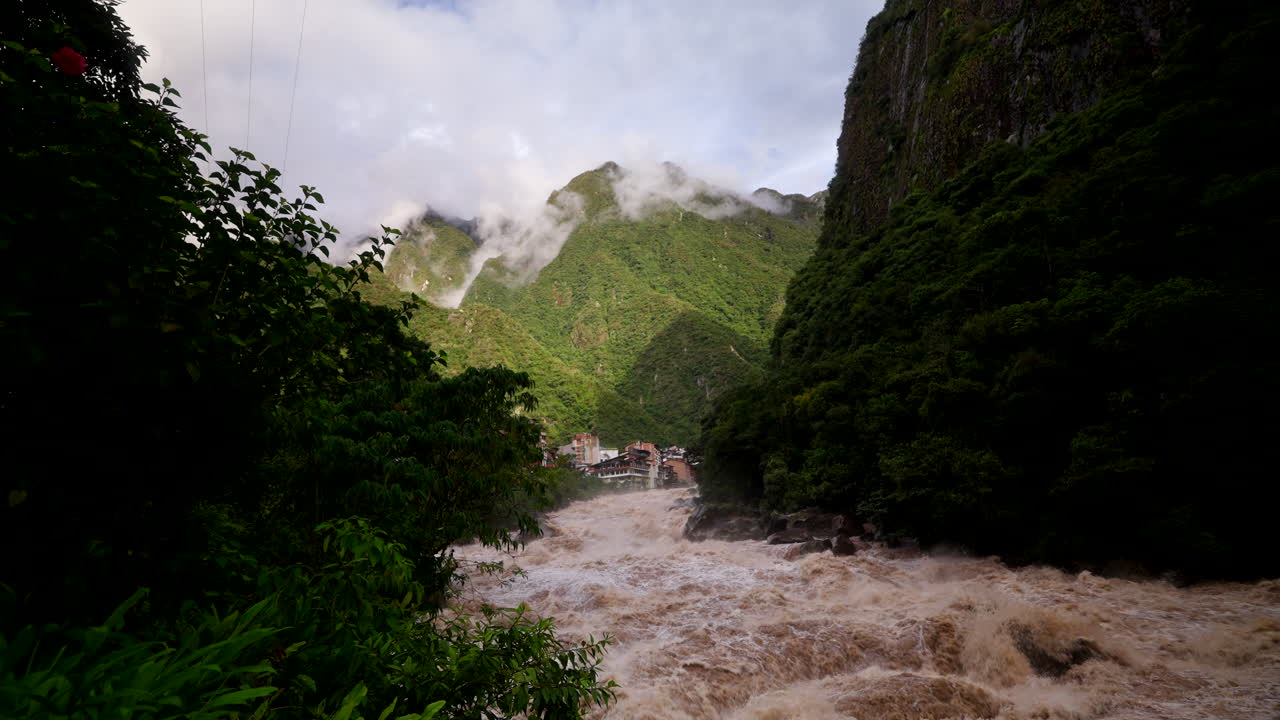 Řeka Urubamba v období dešťů poblíž Aguas Calientes v Peru, kdy stoupá valící se přívalová voda unášející bláto a špínu.