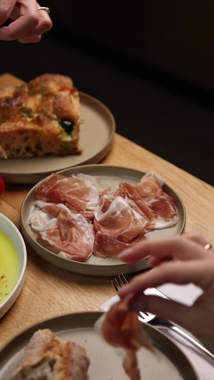 Persone che mangiano jamon e altro cibo