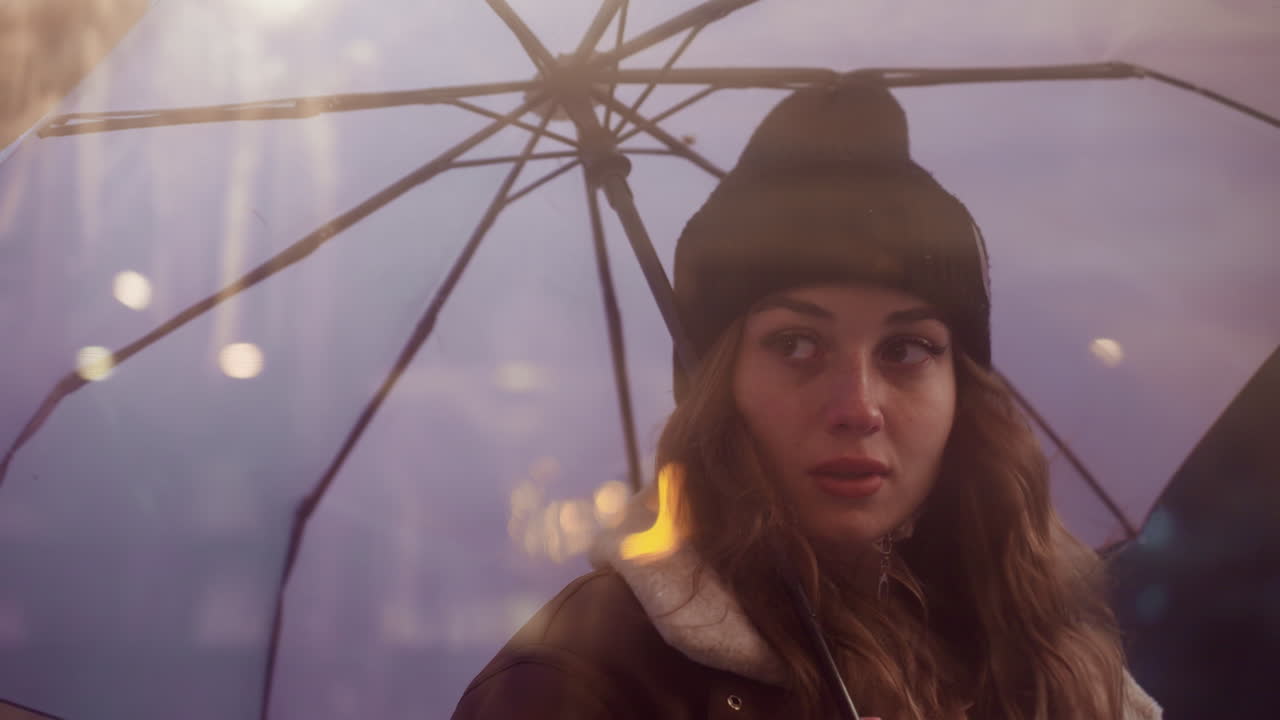 Close shot of female holding umbrella walking past cafe, looking through glass window on cold overcast day, wearing black knit cap, brown shearling jacket, with rainy atmosphere outside