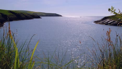 footage from the grassy ground on to the sparkling blue ocean and cloudless sky