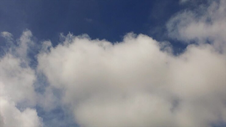 moving white cumulonimbus clouds in the blue sky, point of view