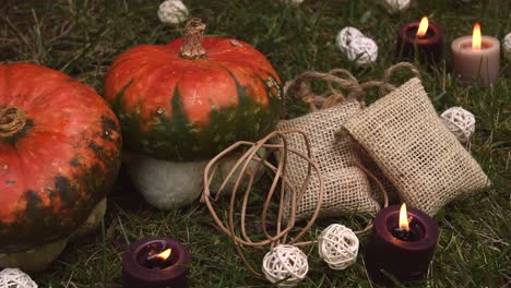 autumnal background with pumpkins and candles with flames moving in the wind