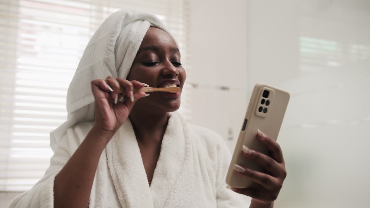 Woman Checking Cellphone when Brushing Teeth as Morning Routine