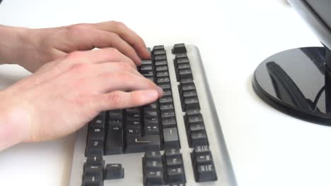 man typing on computer keyboard