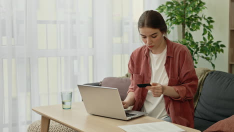 mujer que utiliza una computadora portátil y una tarjeta de crédito para el pago en línea