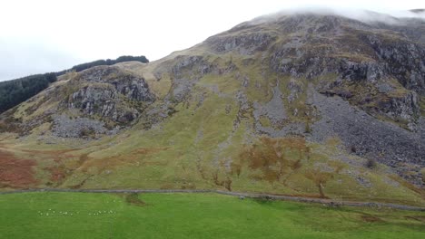 aerial video of green and rocky scottish highlands with any paths and white sky