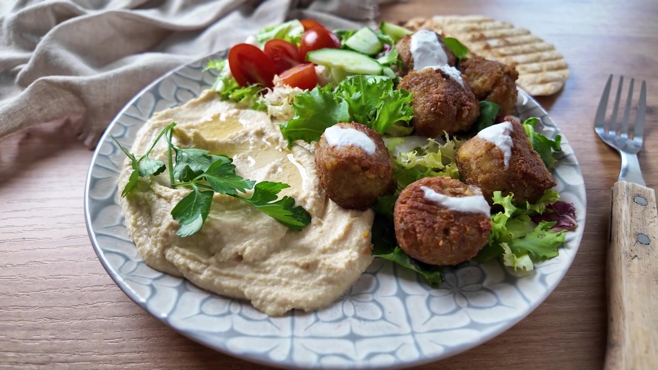 Falafel tradizionale servito con hummus e insalata fresca.