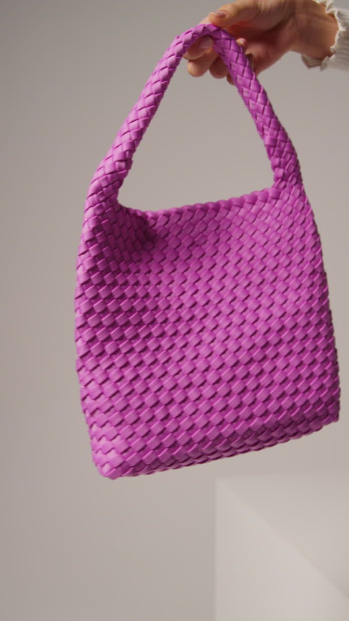 video vertical de cerca de una influyente femenina de las redes sociales produciendo contenido generado por el usuario sosteniendo una bolsa de moda púrpura