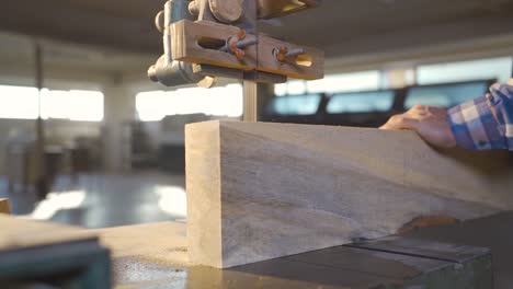 cutting wood with band saw in carpentry workshop.