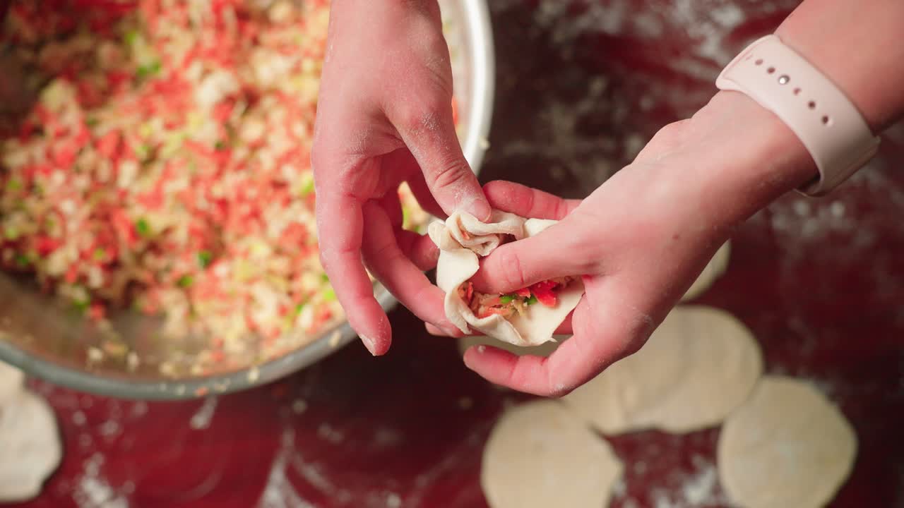 Hand folding a fresh dumpling with homemade dough