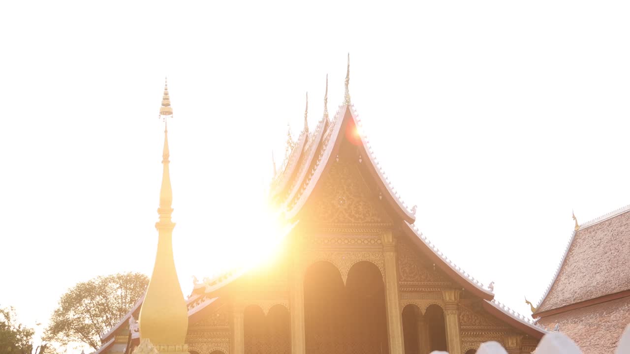 golden sun flare over buddhist temple in Luang Prabang, Laos traveling Southeast Asia