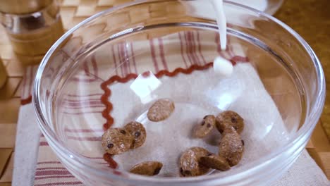 copos de chocolate crujientes en un tazón para un delicioso desayuno matutino con leche. cámara lenta con toma de seguimiento de rotación.