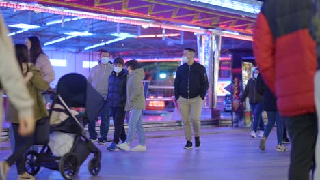 people at a winter funfair with masks