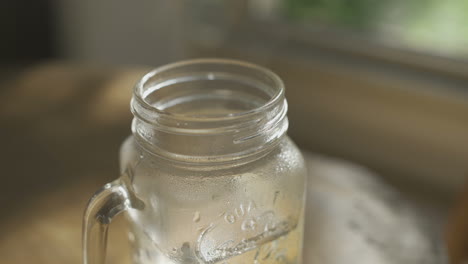 Close-Up-of-glass-mug-with-hot-water-set-on-table