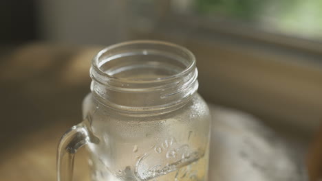 primer plano de una taza de vidrio con agua caliente en la mesa