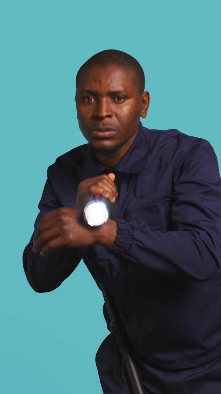 African American Security Guard Searching with Flashlight