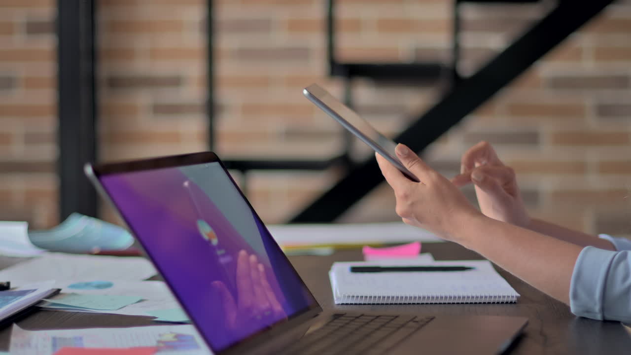 Mulher de blazer azul trabalhando em um tablet em uma mesa em um escritório