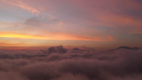 the beautiful fiery orange sunset view above the clouds of bali, indonesia - aerial shot