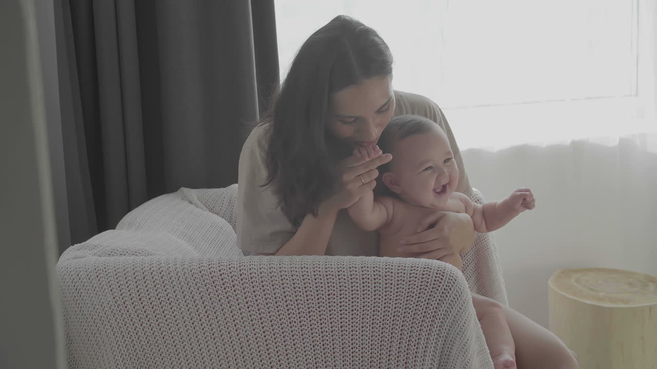 mamá feliz besa a su lindo bebé en casa
