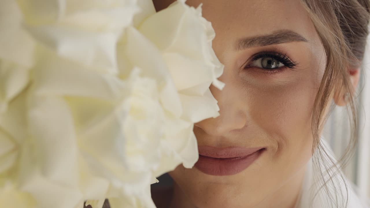 bella sposa sorridente con un bouquet di rose bianche