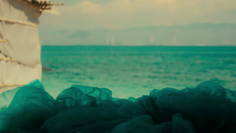 teal fabric draped on beach, coastal landscape