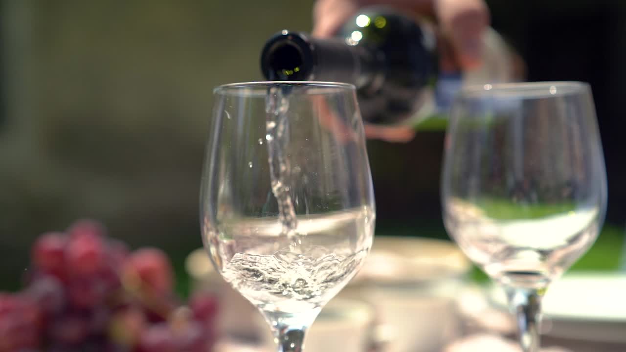 versando vino bianco fuori in una giornata di sole al rallentatore