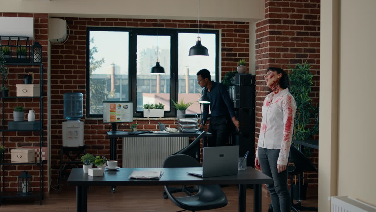Vittima spaventata in ufficio che si nasconde da spaventosi zombie insanguinati