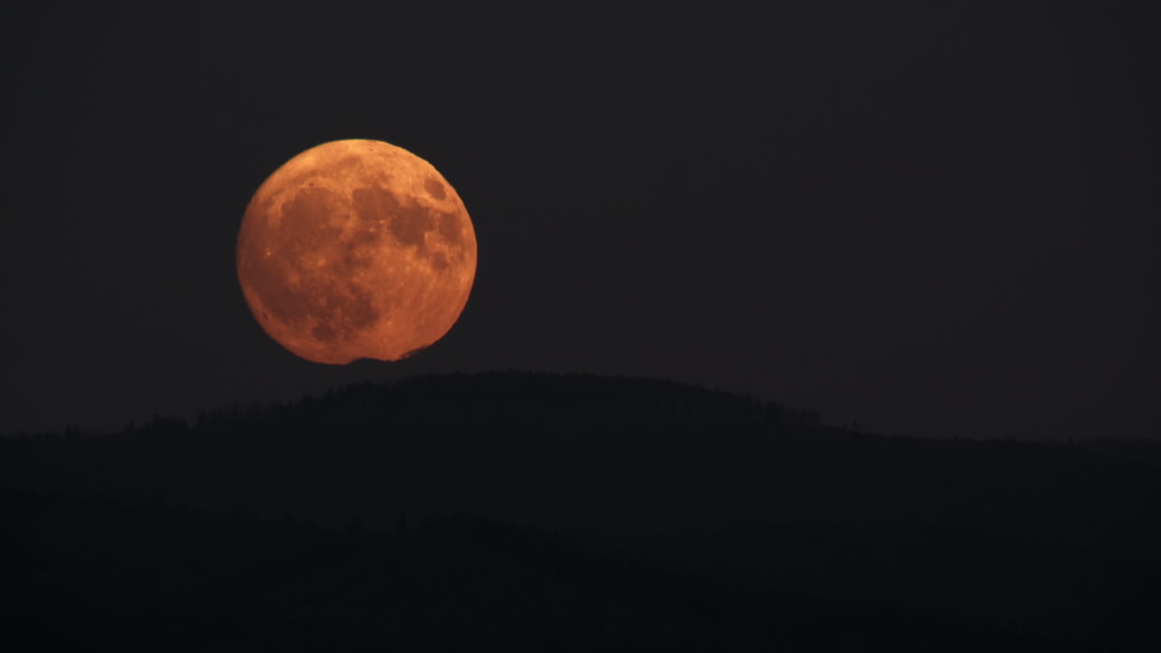 Stunning Full Orange Moon Rising Over Mountains at Night