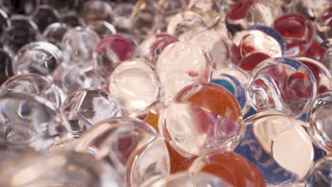 Macro-view-of-glass-spheres-wet-abstract-light-reflections-with-colors,-interesting-4k-bright-background-footage,-backlit-balls