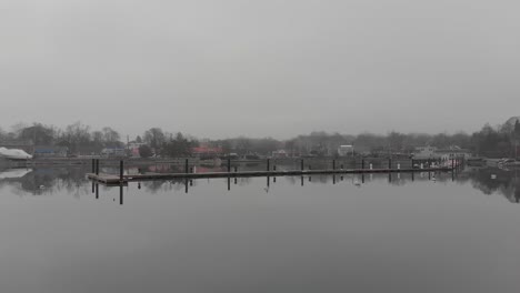 Eine-Ruhige-Bewegung-Der-Drohne-Am-Uferdock-An-Einem-Kalten,-Nebligen-Tag