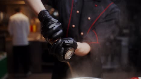 chef grinding pepper in a commercial kitchen