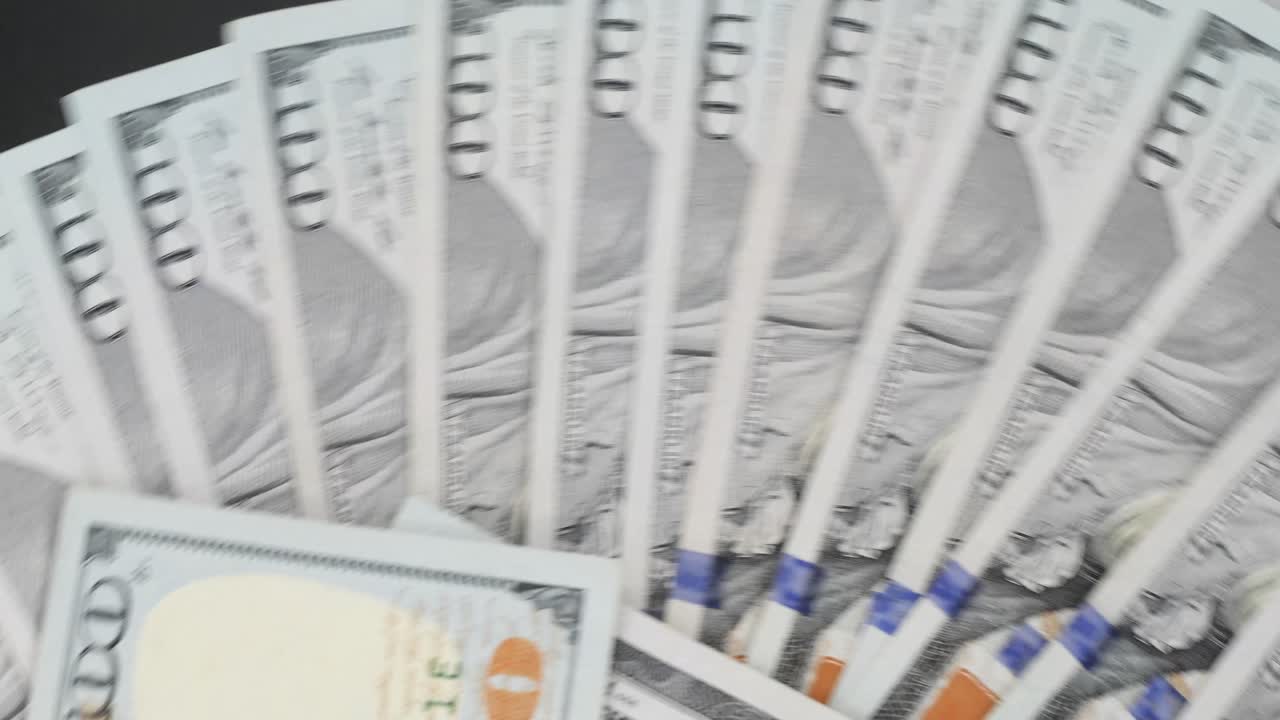 탁자 위에서 회전하는 100달러 지폐