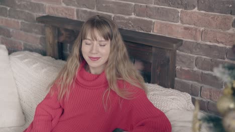 beautiful girl in red knitted sweater smiles and looks away