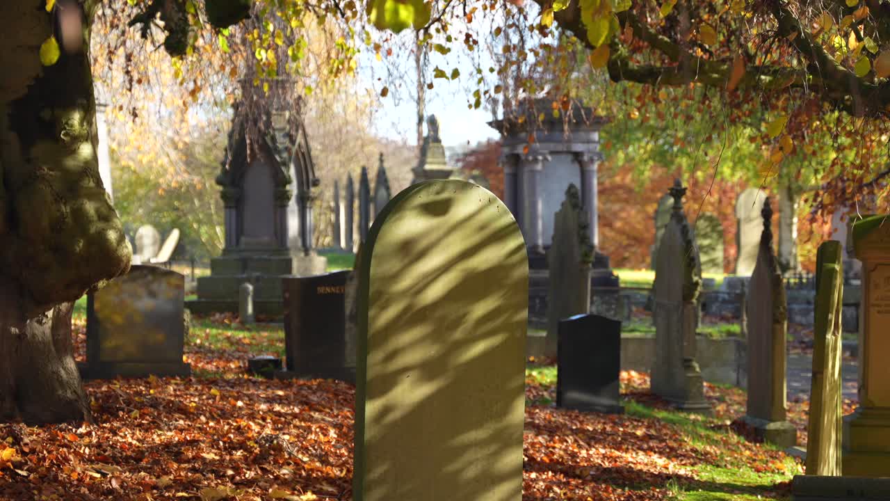 Aged headstones in Autumn in peaceful historic British graveyard