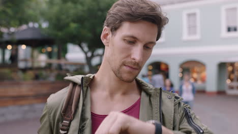 portrait-of-handsome-young-man-looking-at-wrist-watch-on-busy-urban-background