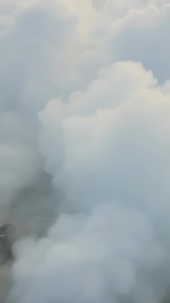 Vertical video: Crashing wave sending white spray rising and spreading over rocky shore, near rocks