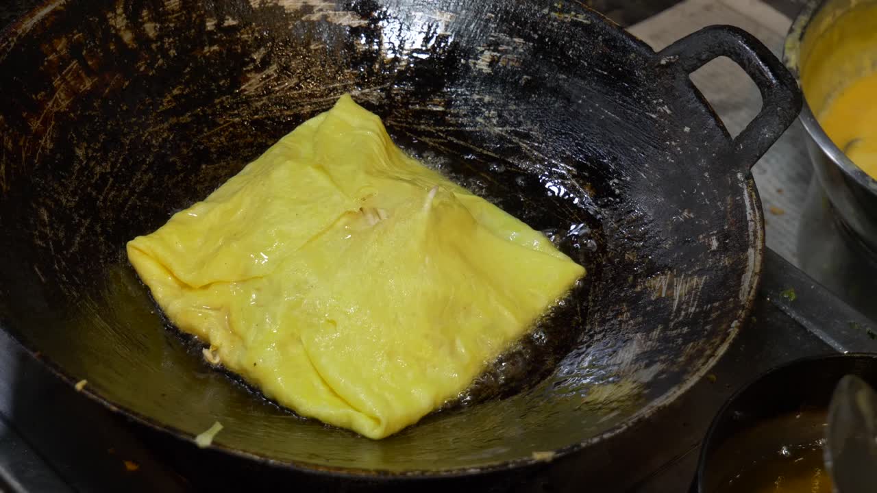 cocinar tortilla con vegetales en el mercado nocturno de la calle asiática en el puesto de comida callejera en verano caliente