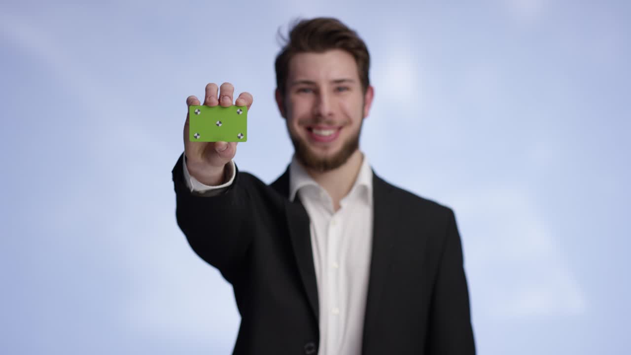 Handsome and young man raising his buisness card into the frame