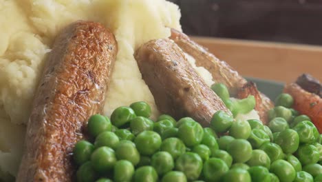 Freshly-Cooked-British-Cuisine-Bangers-and-Mash-with-Peas-and-Carrots