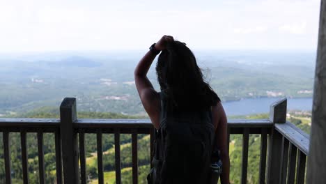 female hiker looking at at view from the top of a mountain on a sunny summer day in quebec