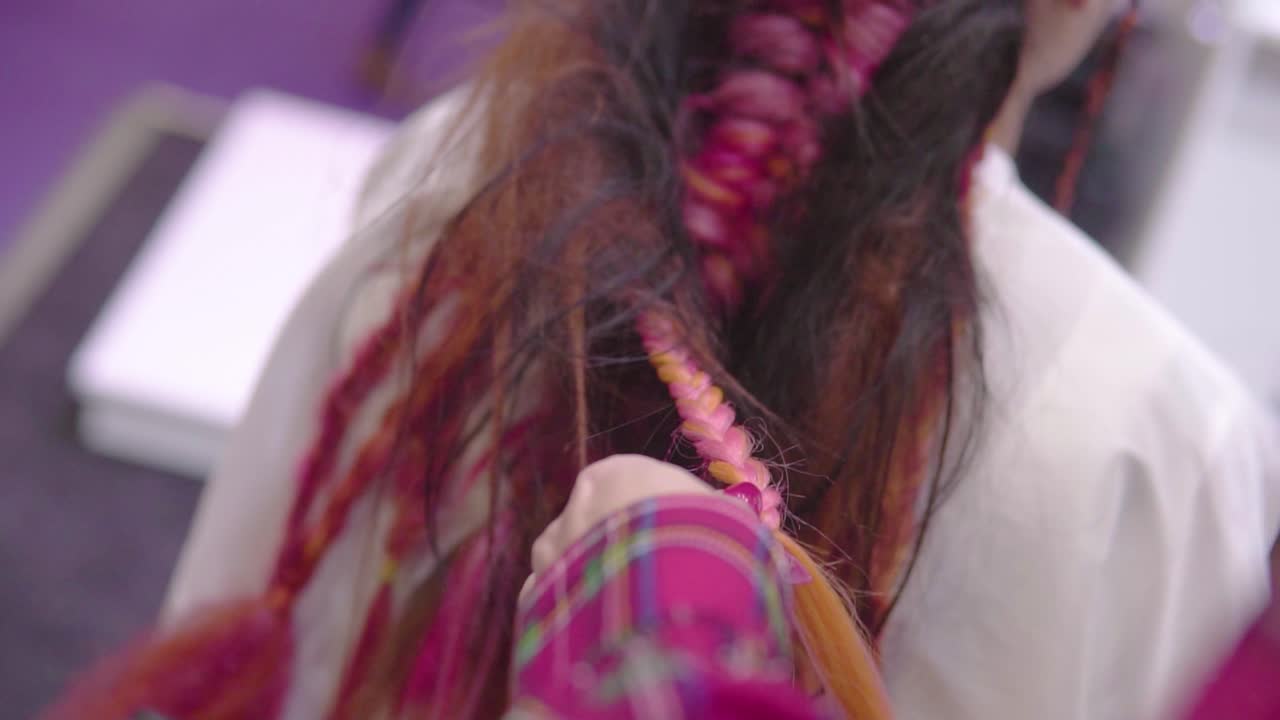 hands close up braiding pink hair female customer extravagant hairstyle slow motion