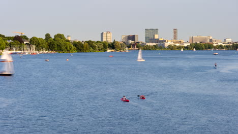 beautiful time lapse of außenalster with many sailing boats and canoes passing by on sunny day in hamburg, germany