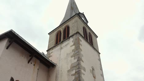 Low-angle-shot-of-church-tower-bell-in-beautiful-village-of-Les-Gets-in-France