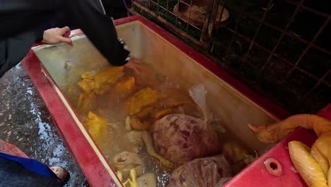 person cleaning and cutting chicken in a tub