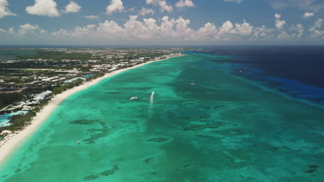 high-altitude aerial flyover of the beautiful blue caribbean water along seven mile beach in grand cayman