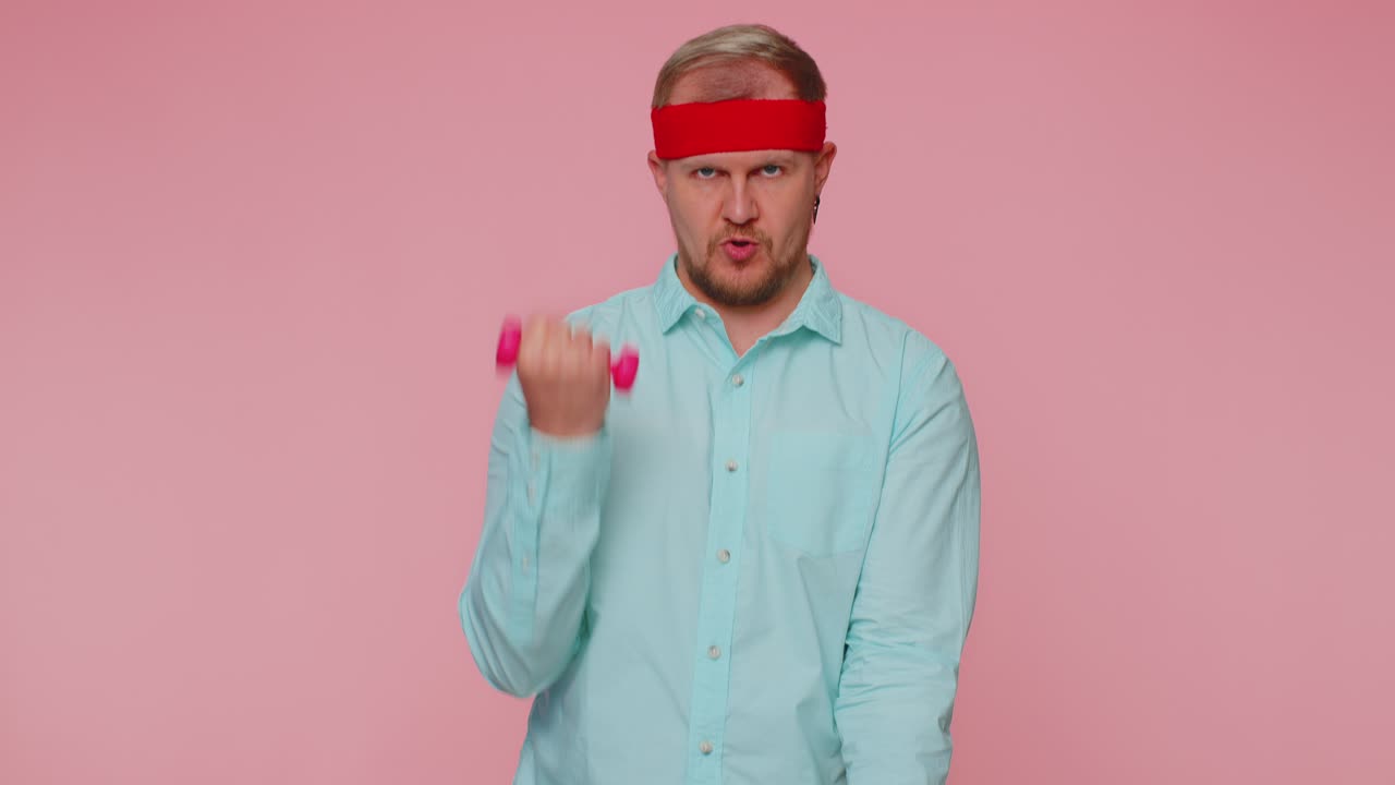 Young adult man making fitness exercises with dumbbells alone working out pumping up arm muscles
