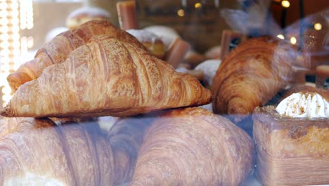 close up of freshly baked croissants and pastries in a bakery display