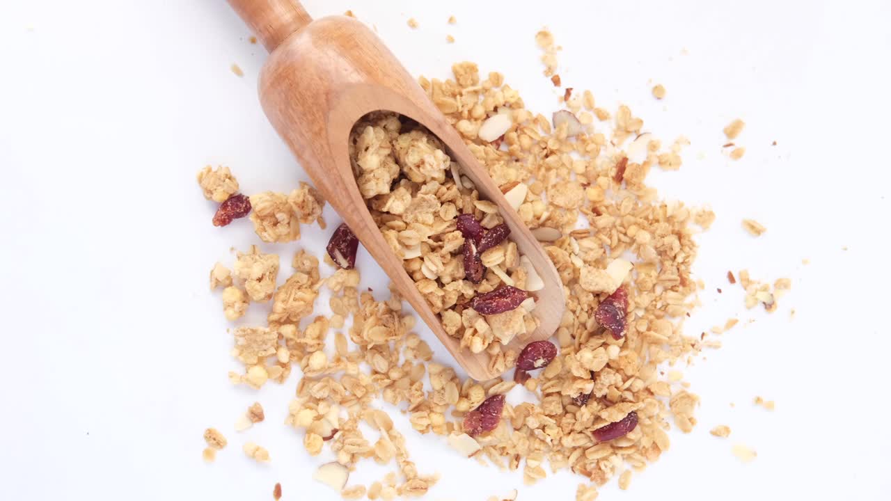 cuchara de madera de granola con almendras y arándanos